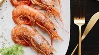 روبيان مشوي مع صوص أخضر على طبق أبيض